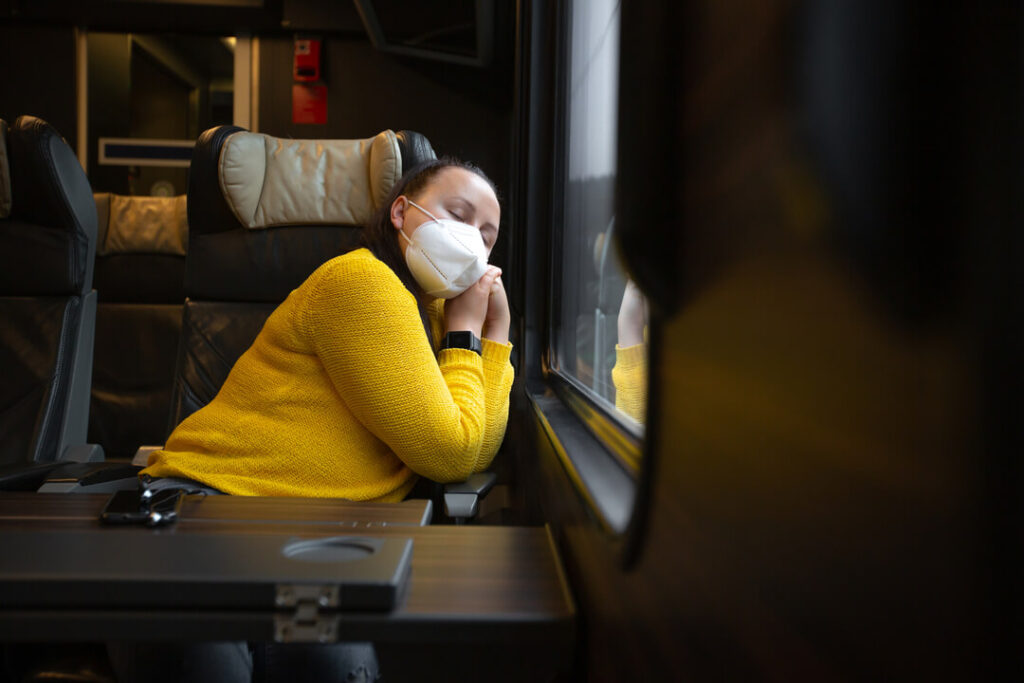 Śpiąca kobieta w pociągu, zmęczona przez jet lag.