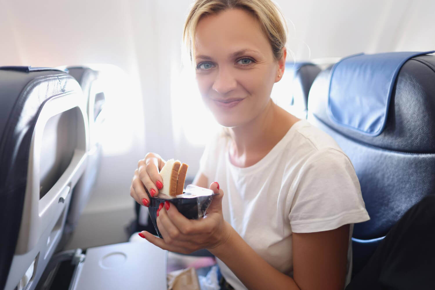 kobieta, która je kanapki na pokładzie samolotu