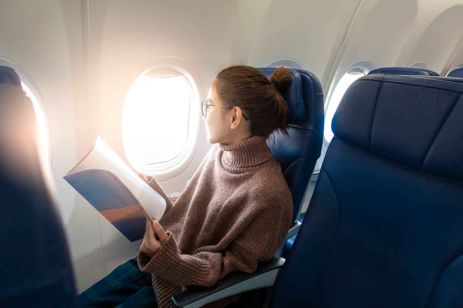 kobieta podziwia widoki, lecąc pierwszy raz samolotem
